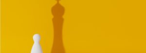 White pawn and shadow king chess pieces in front of yellow background | EOS efficiency with Traction Tools